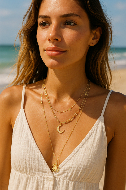 Frau am Strand trägt ein Collier mit Motiv Sonne Mond und Sternen aus Edelstahl, vergoldet